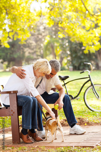 mid age couple playing with pet dog