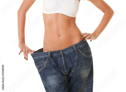 woman shows her weight loss by wearing an old jeans, isolated on © Dmytro Sunagatov
