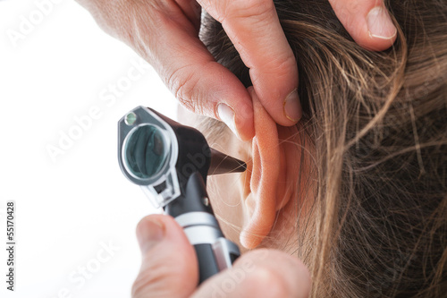Examining ear with otoscope photo