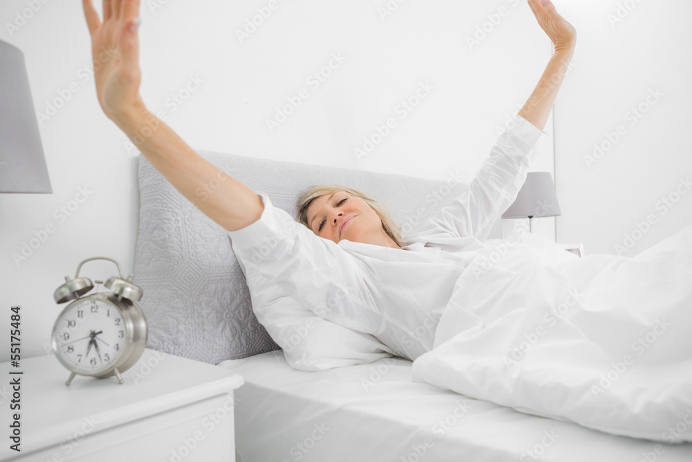 Foto de Well rested woman waking up and stetching do Stock