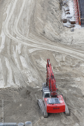 bird's eye fiew of a red digger in sand on a construction area photo