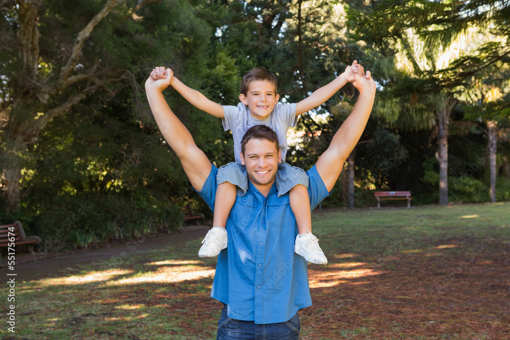 Obraz premium Father holding his son on shoulders
