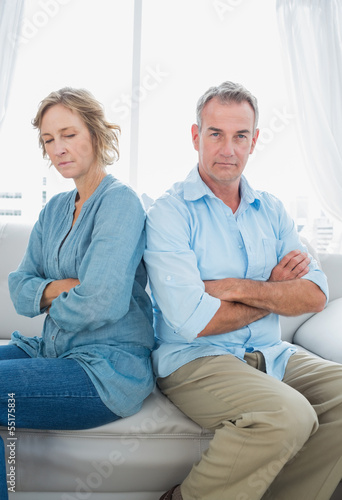 Middle aged couple sitting on the sofa not speaking after a disp photo