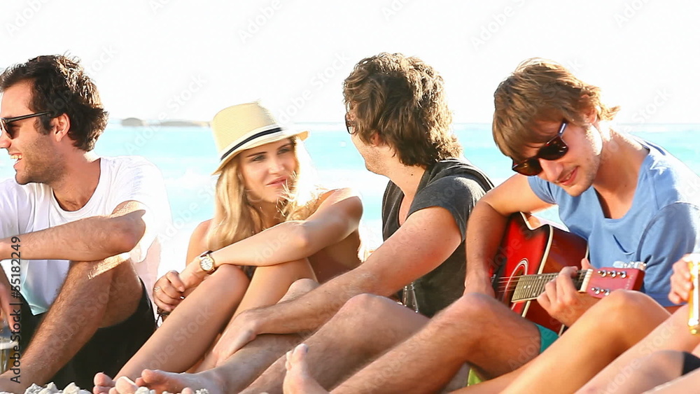 Young hipster people enjoying a beach party with guitar music Young hipster people enjoying a beach party with guitar music