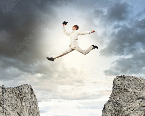 Businessman jumping over gap © Sergey Nivens
