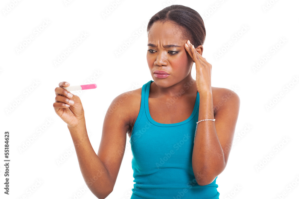 confused african woman looking at pregnancy test confused african woman looking at pregnancy test