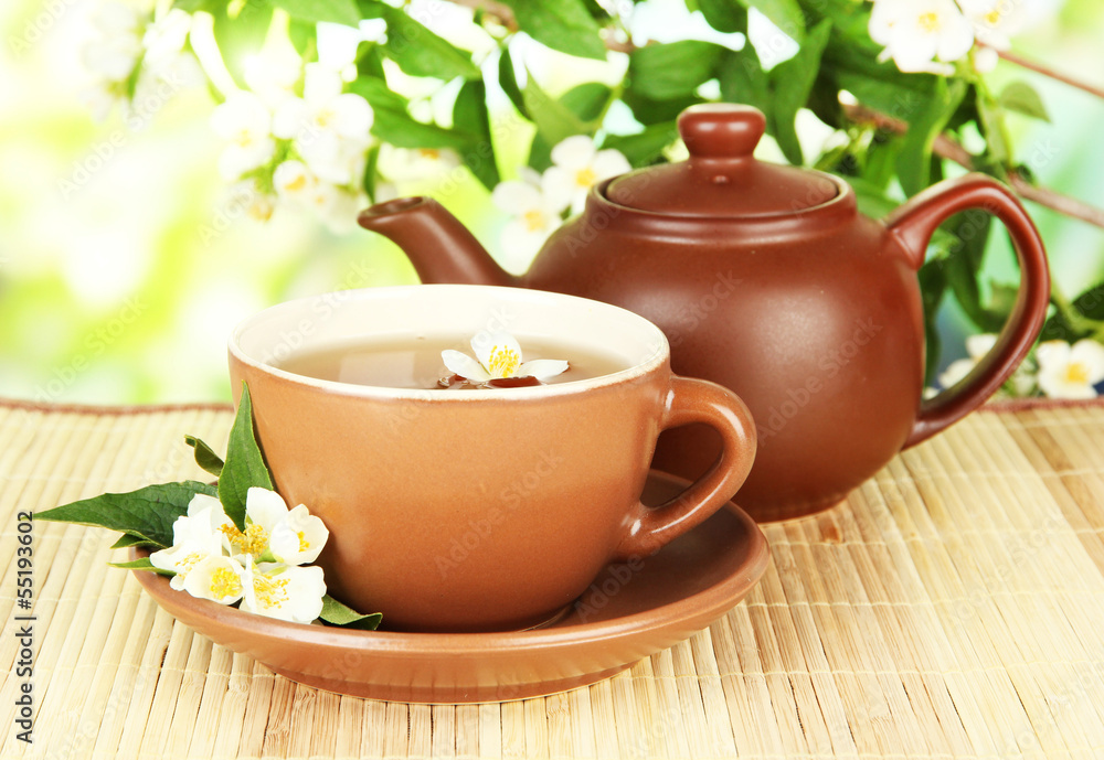 Cup of tea with jasmine, on bamboo mat, on bright background Cup of tea with jasmine, on bamboo mat, on bright background