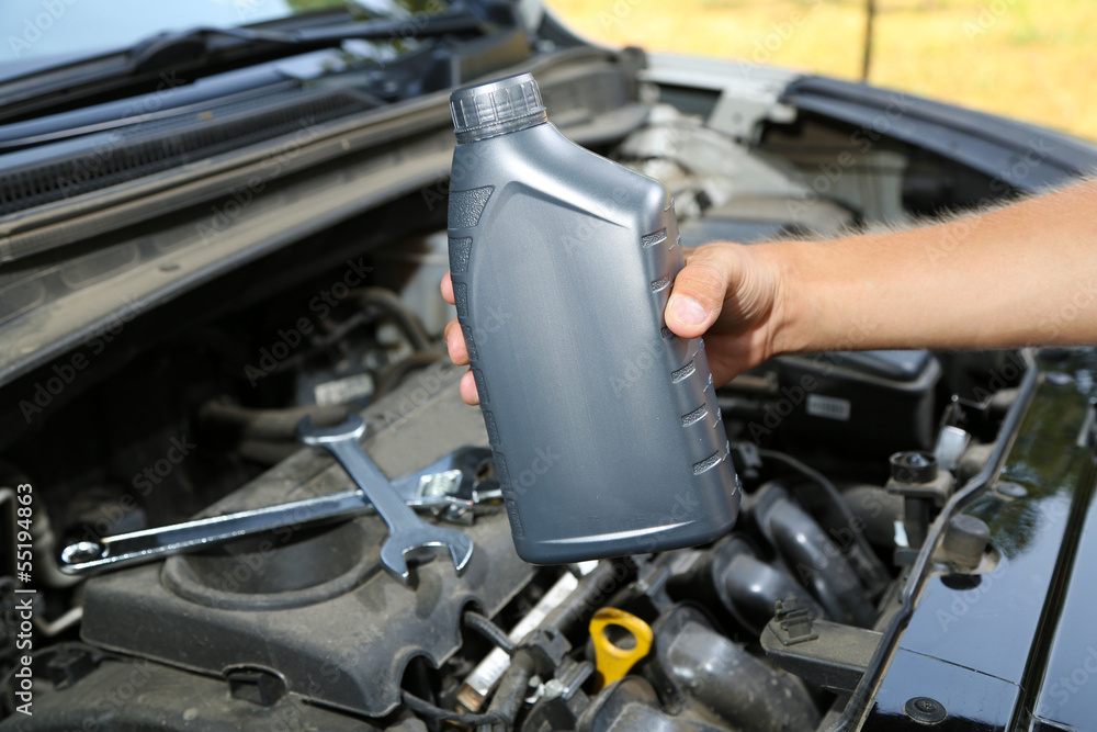 Auto mechanic hand holding motor oil