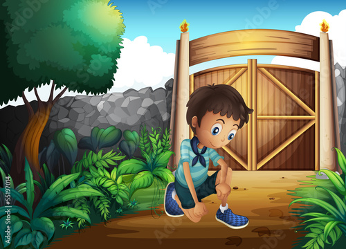 A boy watching the ground inside the gate