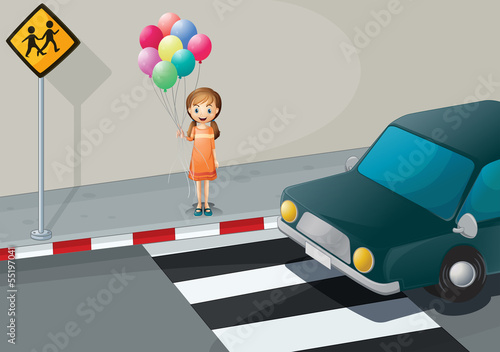A girl near the pedestrian lane holding balloons