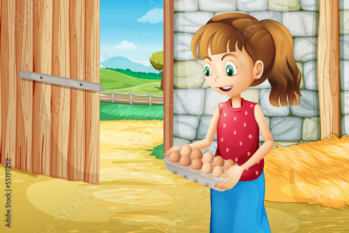 A girl holding an eggtray inside the barnhouse