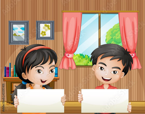 Two kids with empty signboards inside the house