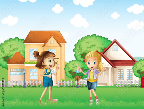 Two young ladies playing in the ground in front of the houses