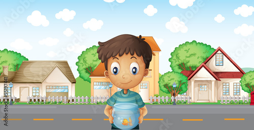 A boy with an aquarium standing across the neighborhood