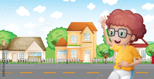 A boy jogging in front of the neighborhood
