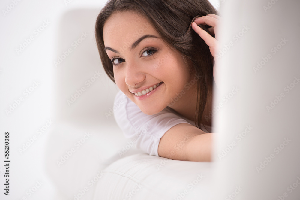 Curious young woman. Smiling young woman lying on the couch and Curious young woman. Smiling young woman lying on the couch and
