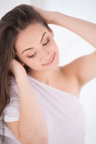 Cute young woman. Beautiful young woman holding her hand in hair