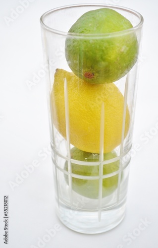 lemons and limes in a glass on a white background.