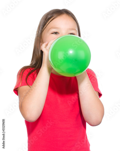 Little girl is inflating green balloon