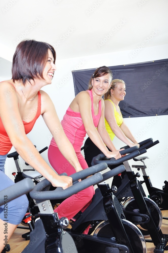 Beautiful women doing exercise in a spinning class at gym Beautiful women doing exercise in a spinning class at gym