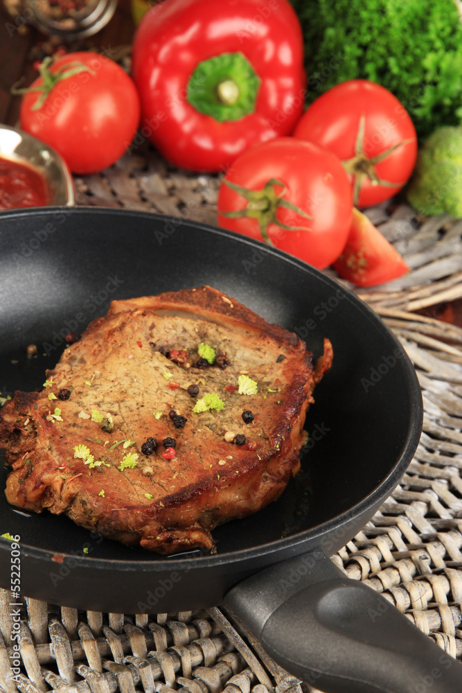Piece of fried meat on pan on wooden table close-up Piece of fried meat on pan on wooden table close-up