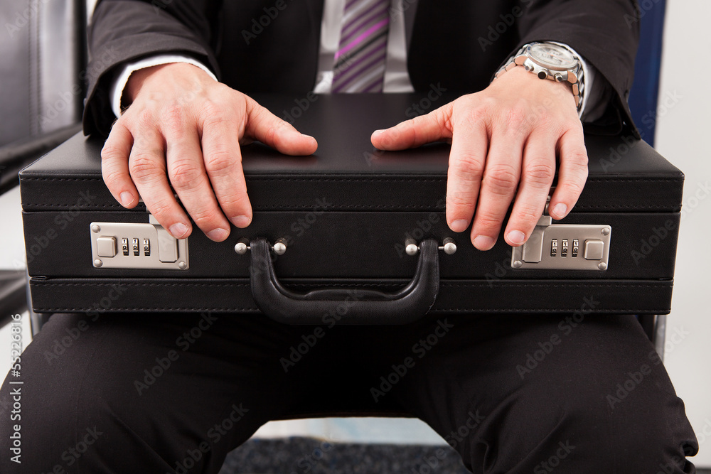 Businessman sitting and holding briefcase