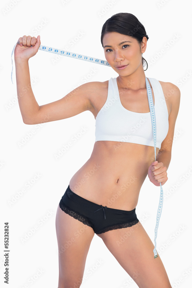Self confident slim woman holding her measuring tape Self confident slim woman holding her measuring tape