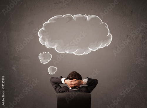 Businessman sitting with cloud thought above his head photo