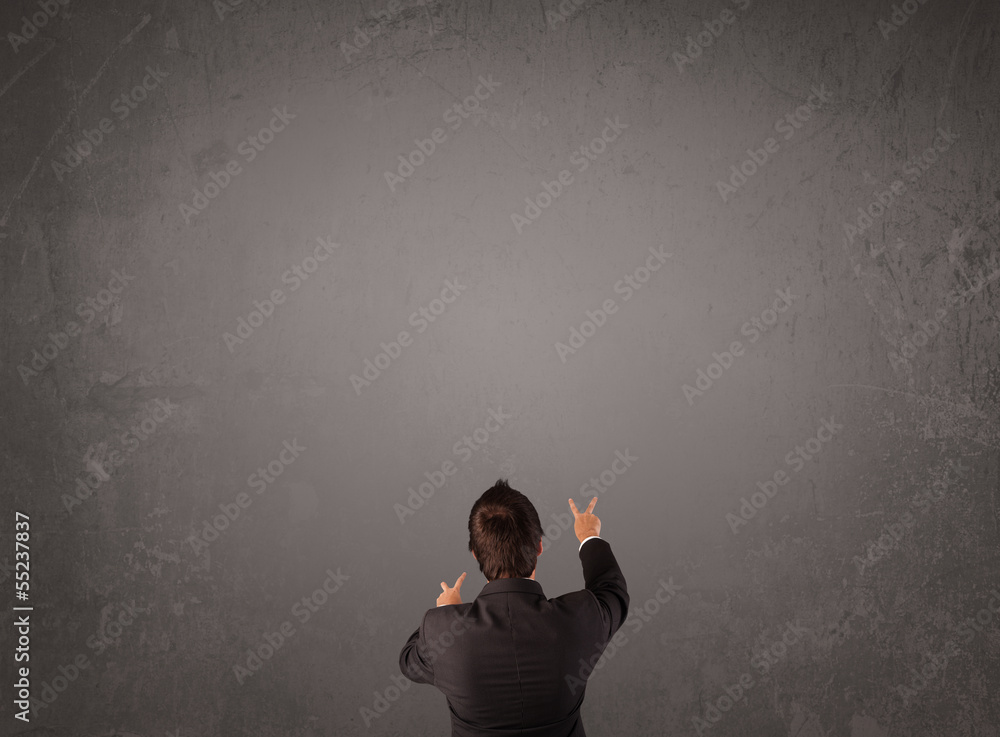 Businessman standing in front of an empty wall Businessman standing in front of an empty wall