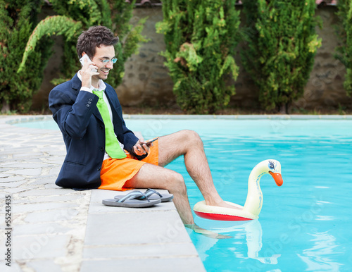 Funny Young Businessman with SwimmingTrunks next to the Pool photo