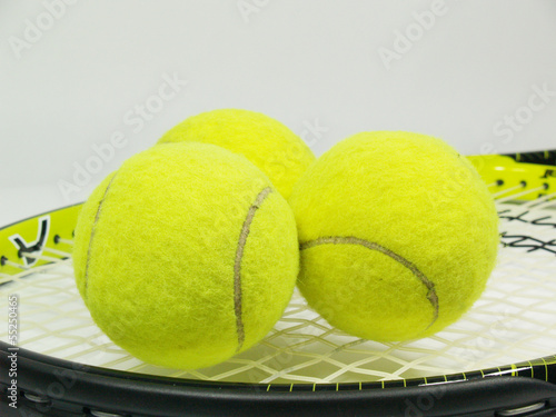 Black and yellow tennis rocket with three yellow balls © nimdamer