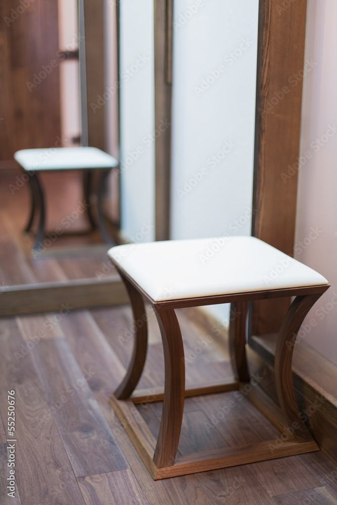 Low square stool with a padded seat in modern interior Low square stool with a padded seat in modern interior