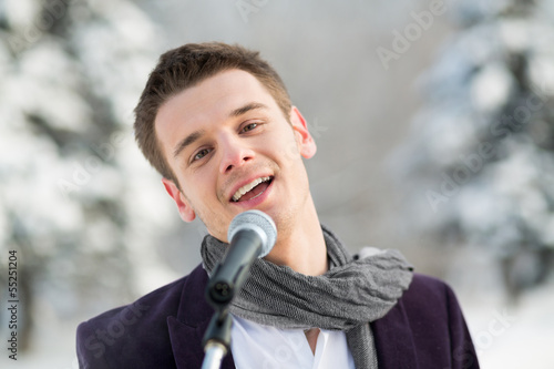 The singer in suit and scarf sing outdoors in winter photo