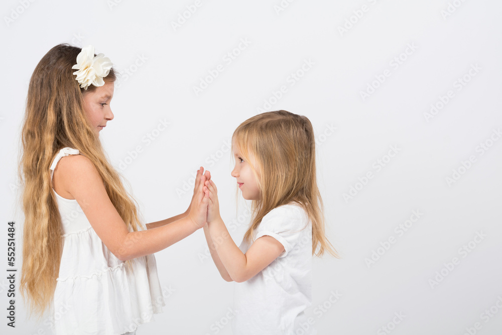 Two little girls playing slapping each others hands Two little girls playing slapping each others hands
