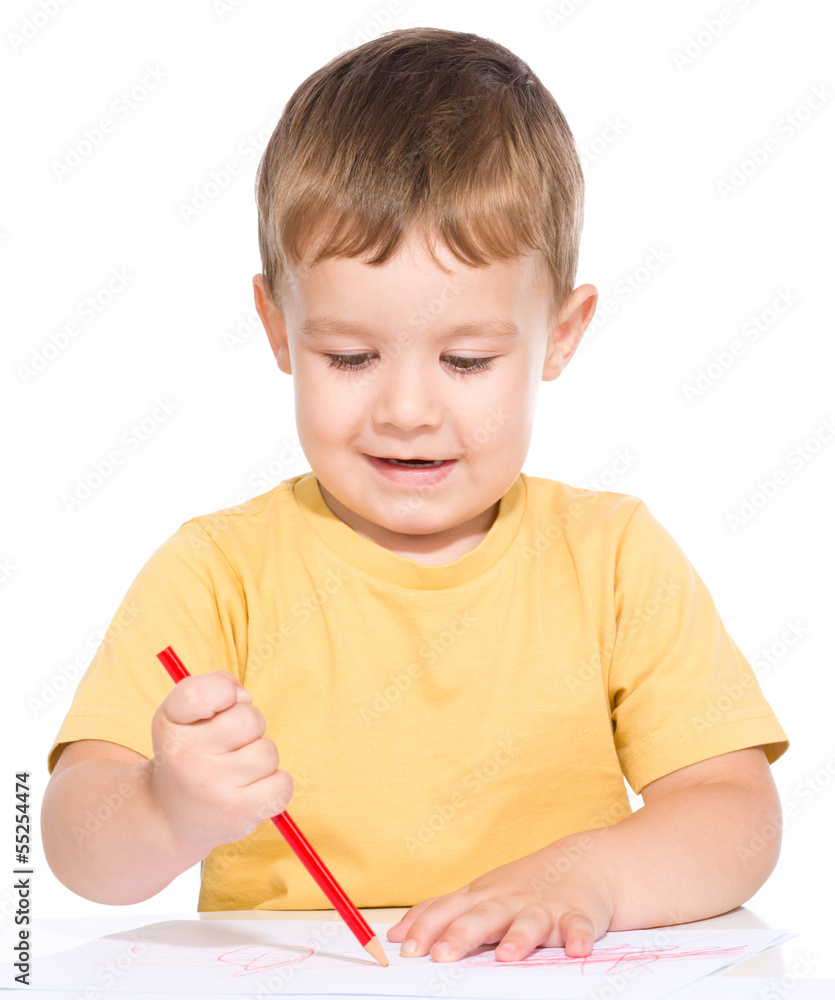 Little boy is drawing using color pencils Little boy is drawing using color pencils