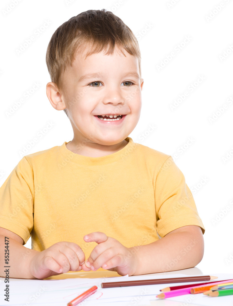 Little boy is drawing using color pencils Little boy is drawing using color pencils