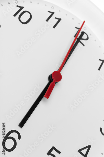 Clock face showing time running to six on white background