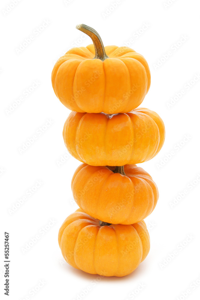 Obraz premium Stack of four mini pumpkins on a white background
