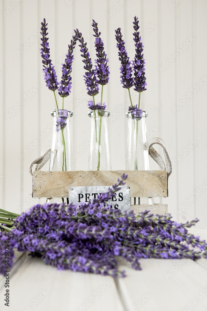 Naklejka premium Three small vases with lavender on a white table