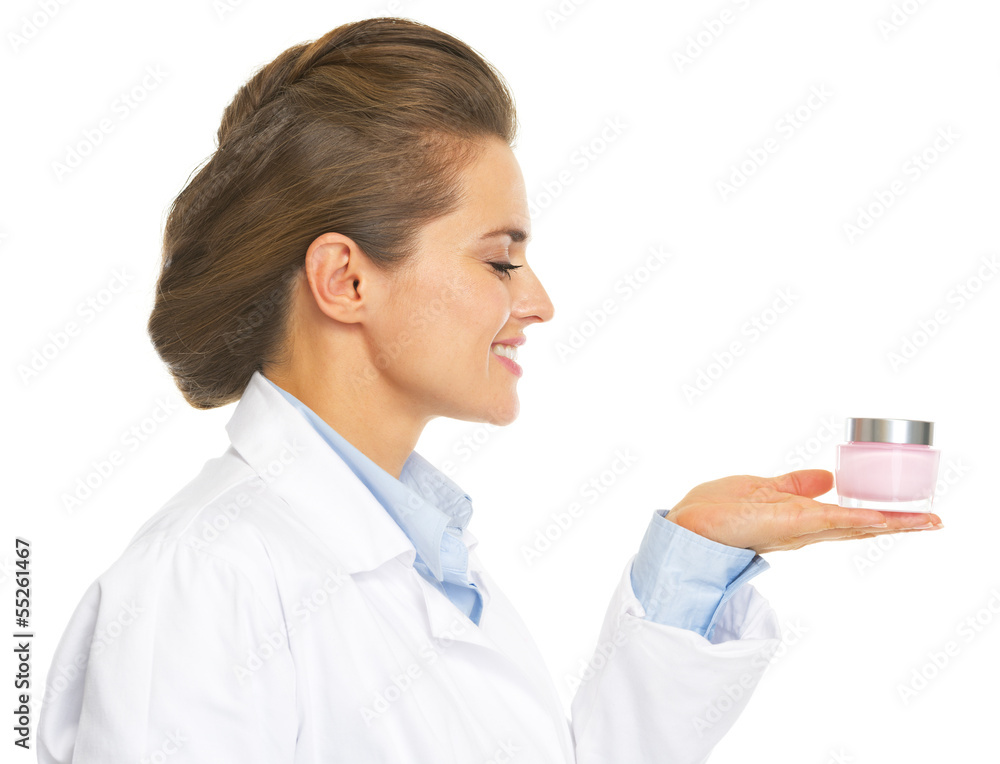 Smiling cosmetologist doctor woman presenting bottle of creme Smiling cosmetologist doctor woman presenting bottle of creme