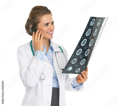 Smiling doctor woman with fluorography talking cell phone photo