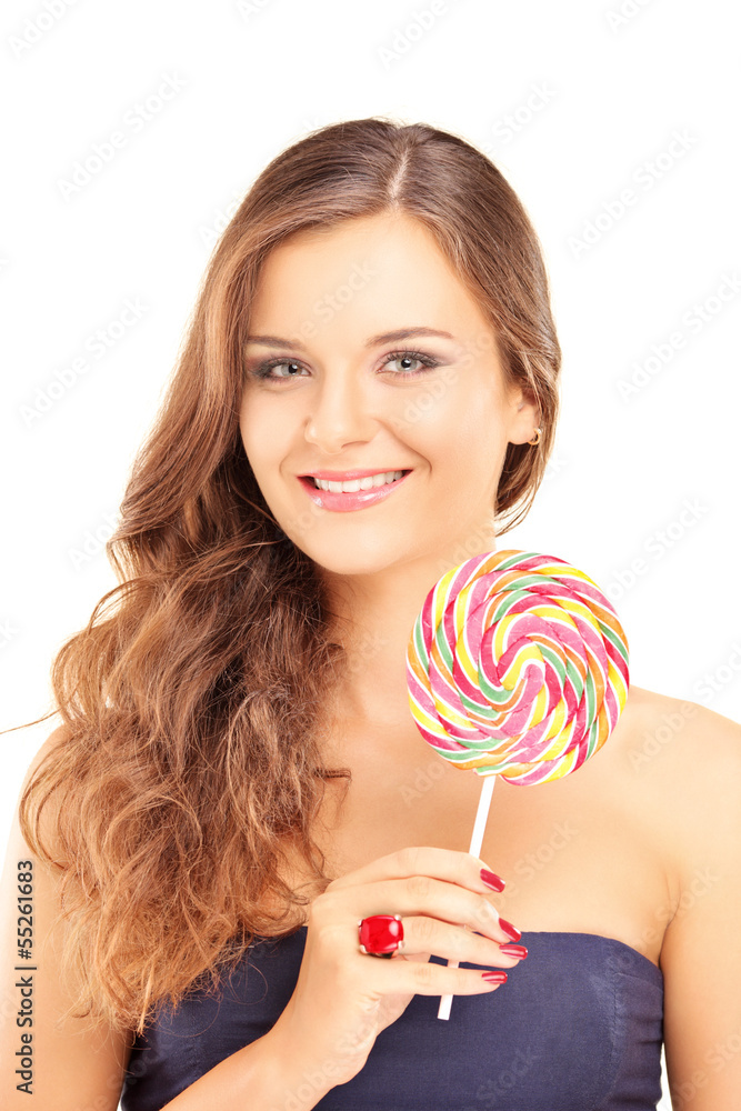 Beautiful female holding a lollipop and looking at a camera
