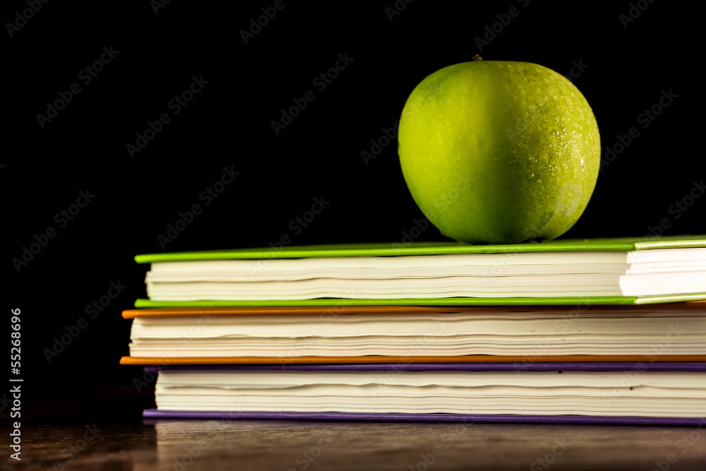 Stack books and green apple