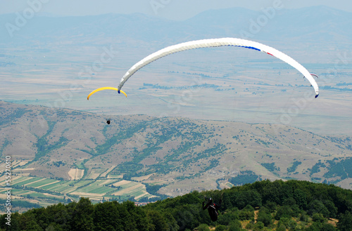 Couple paragliders on the sky