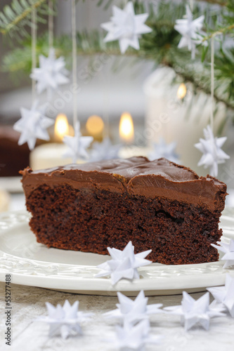 Piece of chocolate cake in white christmas table setting
