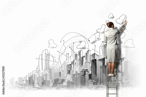 Businesswoman drawing on wall