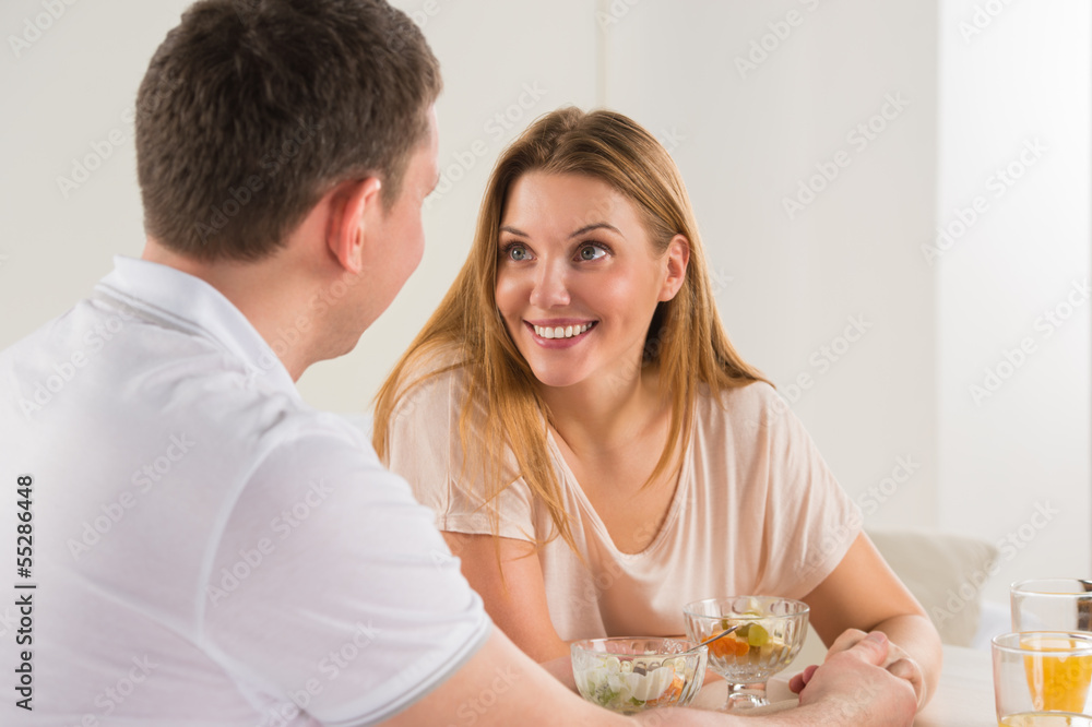 Happy couple eating at home