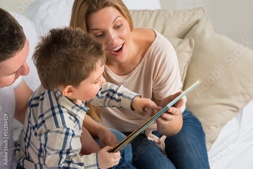 Parents Sitting With Child Reading Story Indoors