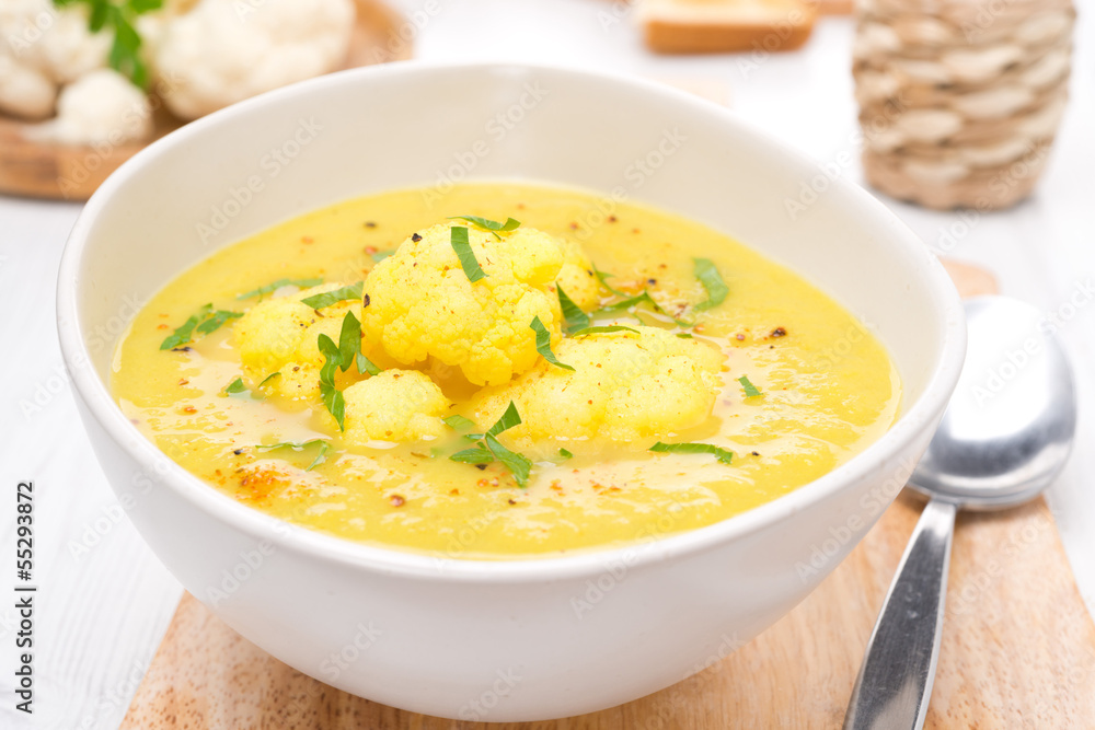 cauliflower soup with curry and cream in a bowl