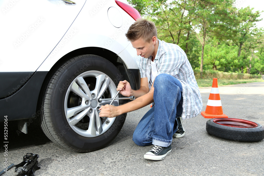 Man driver having trouble at road changing wheel Man driver having trouble at road changing wheel